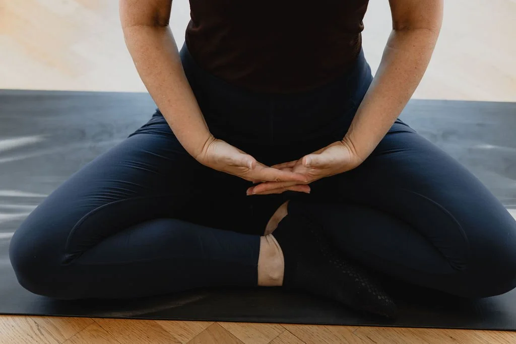 Hands and body seated on a Pilates mat without props