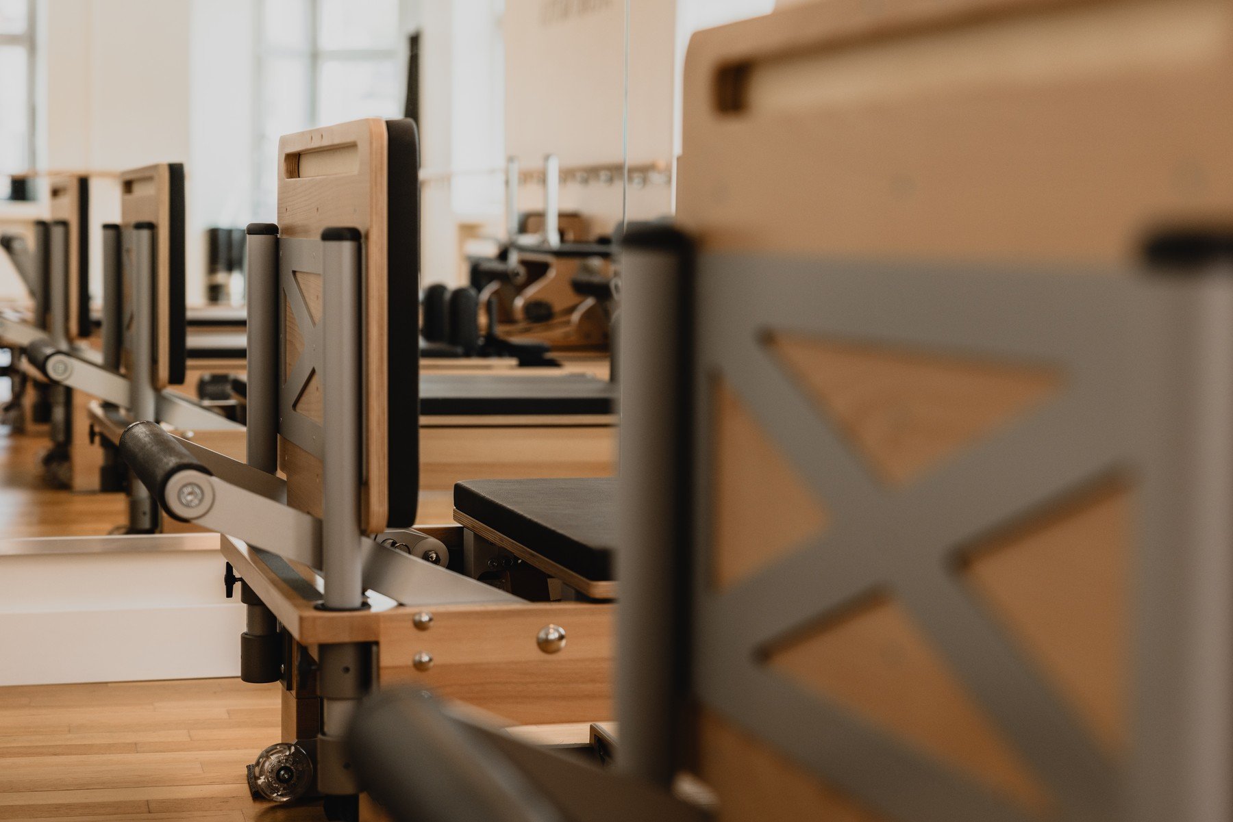 Wooden Wunda Chairs and Reformers arranged in the light-filled studio