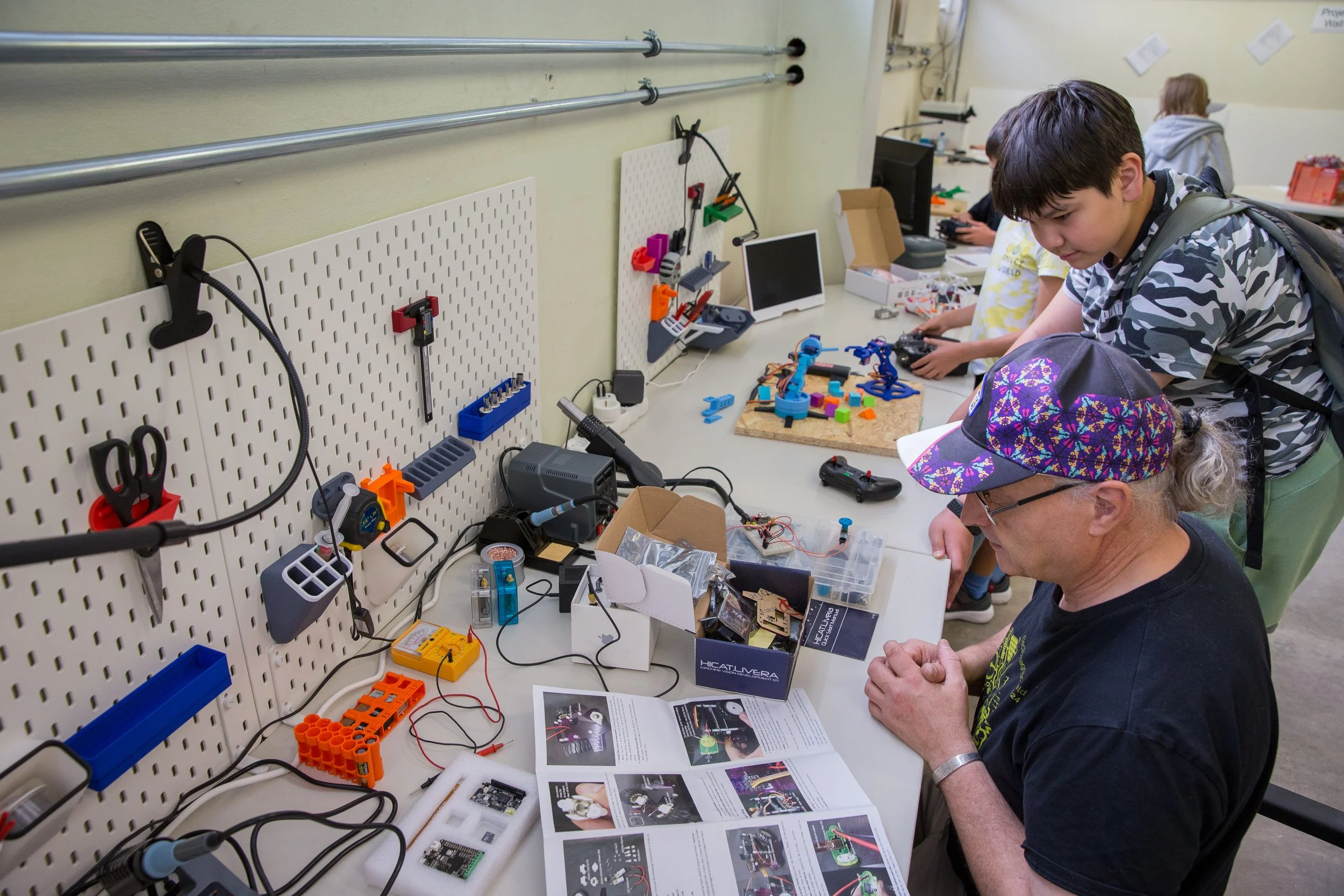 Students gathered around a workbench looking at a project