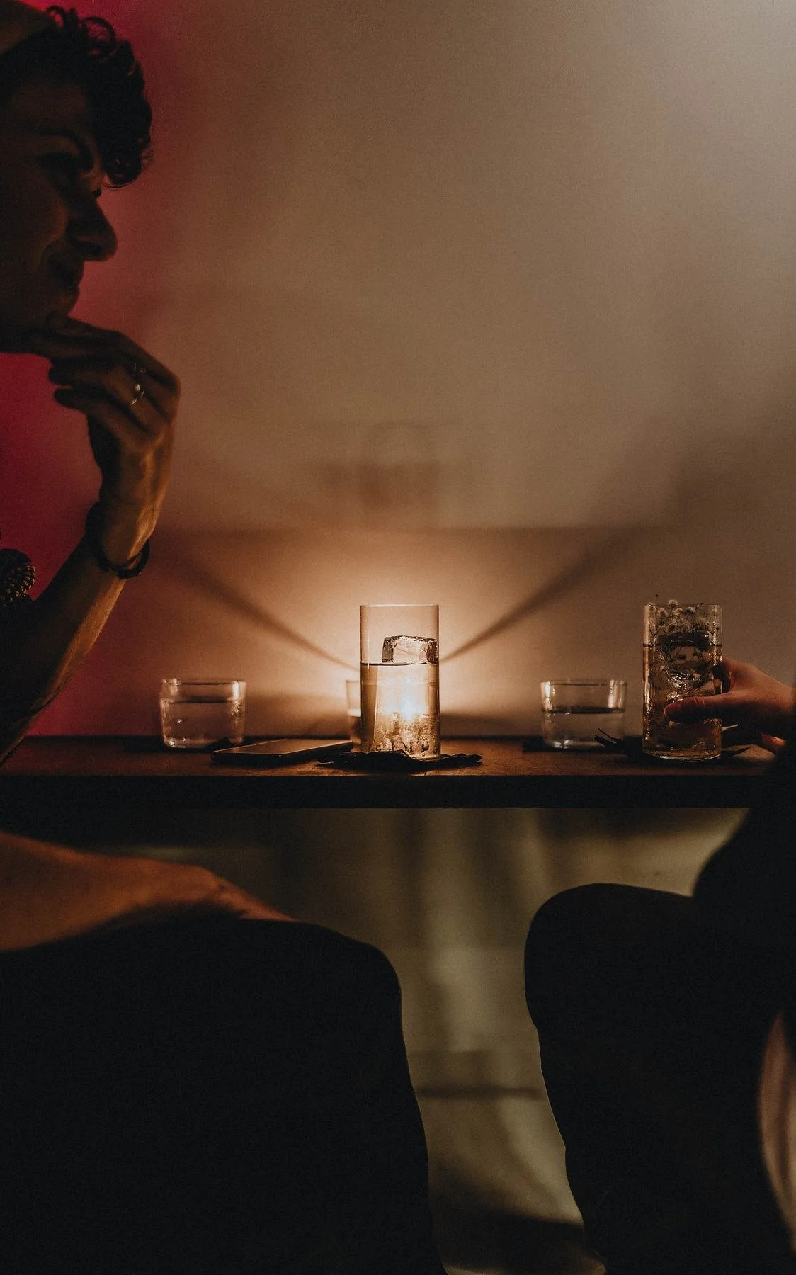 Una mesa a la luz de las velas, un cliente a contraluz.