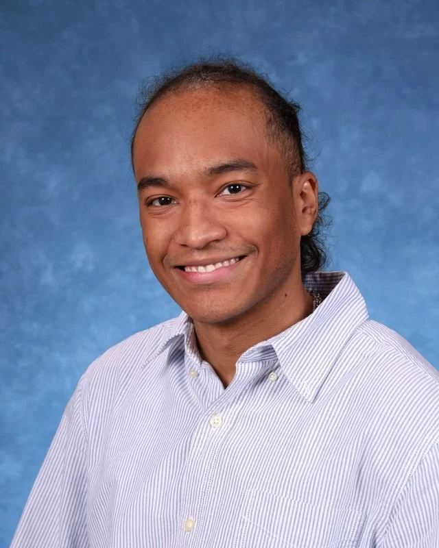 Picture of K. Delacruz, smiling warmly.