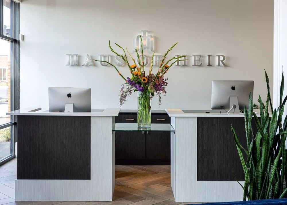 The Haus of Heir wordmark on the wall above the reception desk