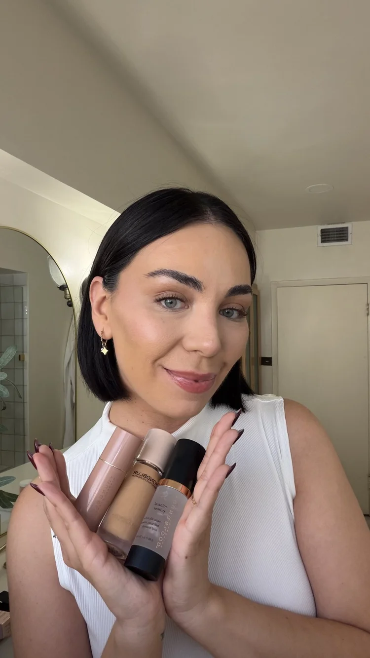 A creator holding BeyondBlur foundation, primer and a highlighter stick