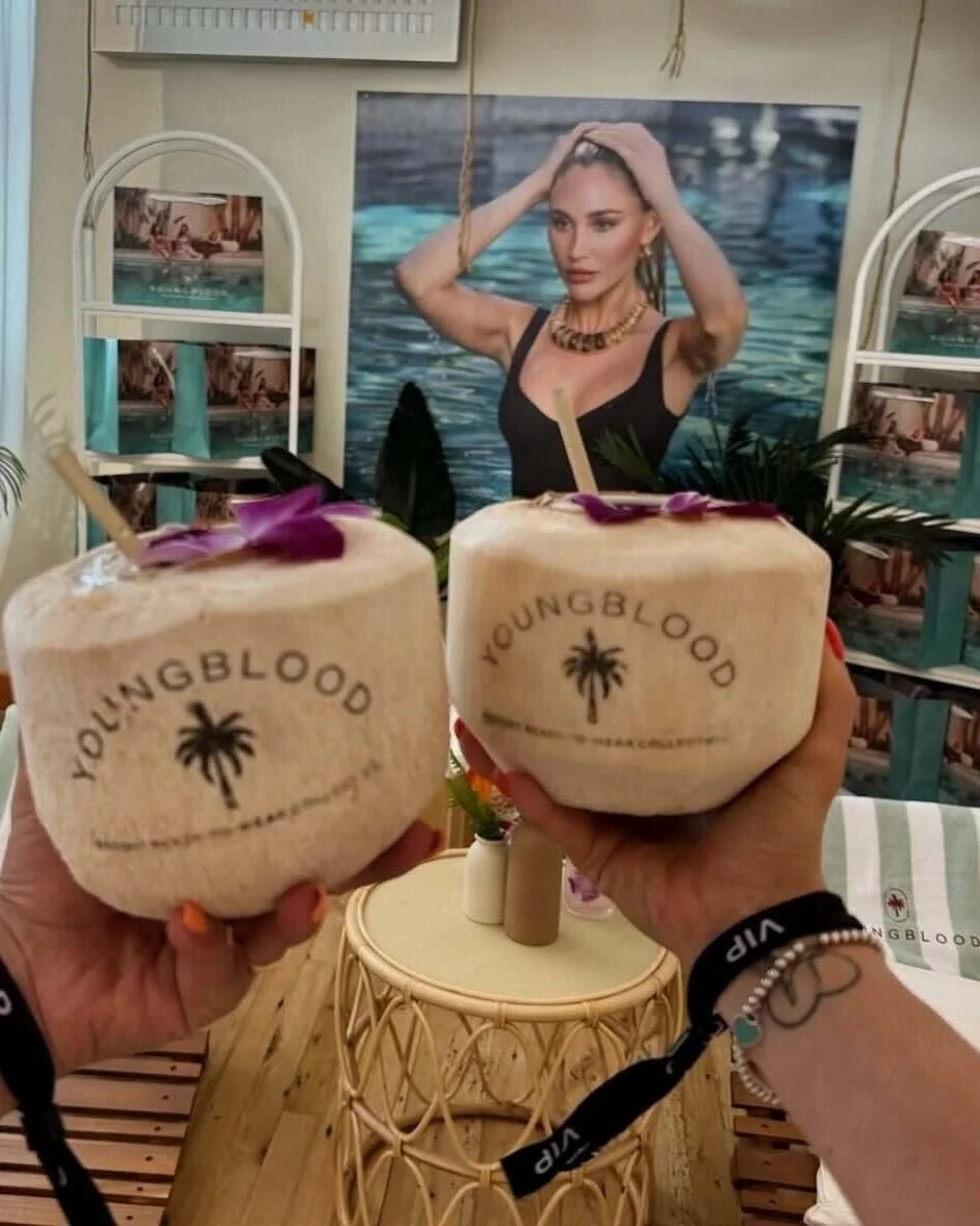 Two branded coconut cocktails held up with VIP wristbands
