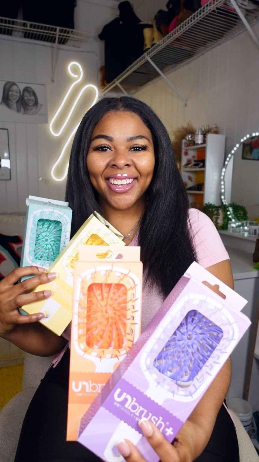 A creator holding a stack of detangling brushes in their boxes