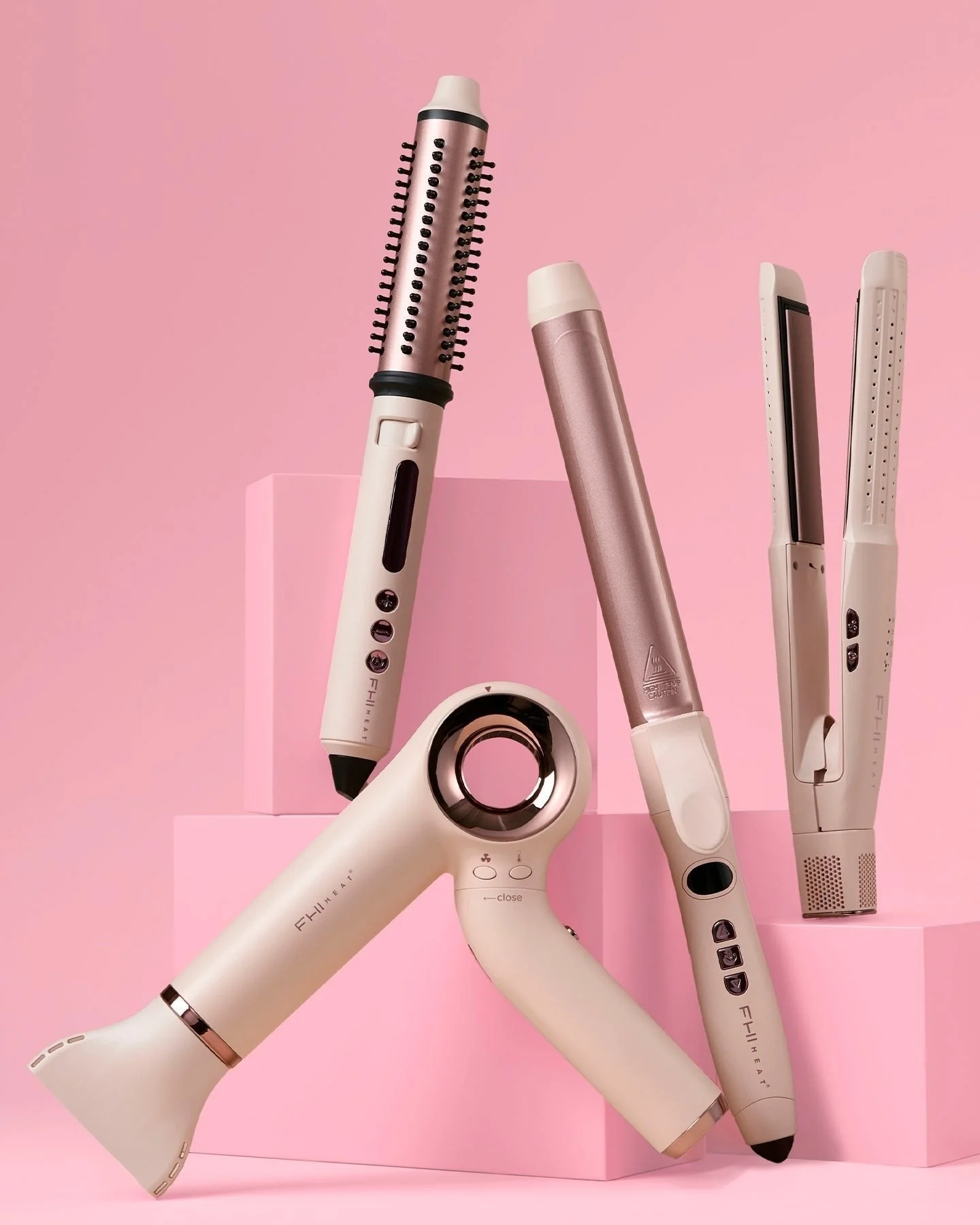 A cream hair tool collection on pink plinths