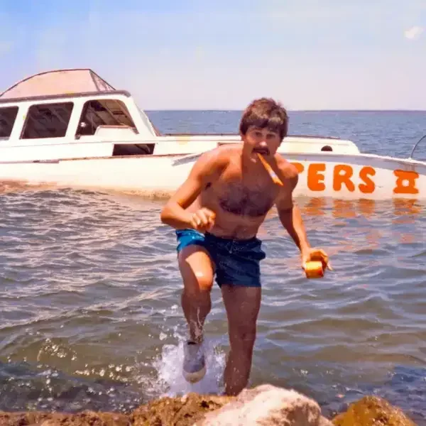 Vintage photo of a white boat with Hooters hand-painted in orange across the hull