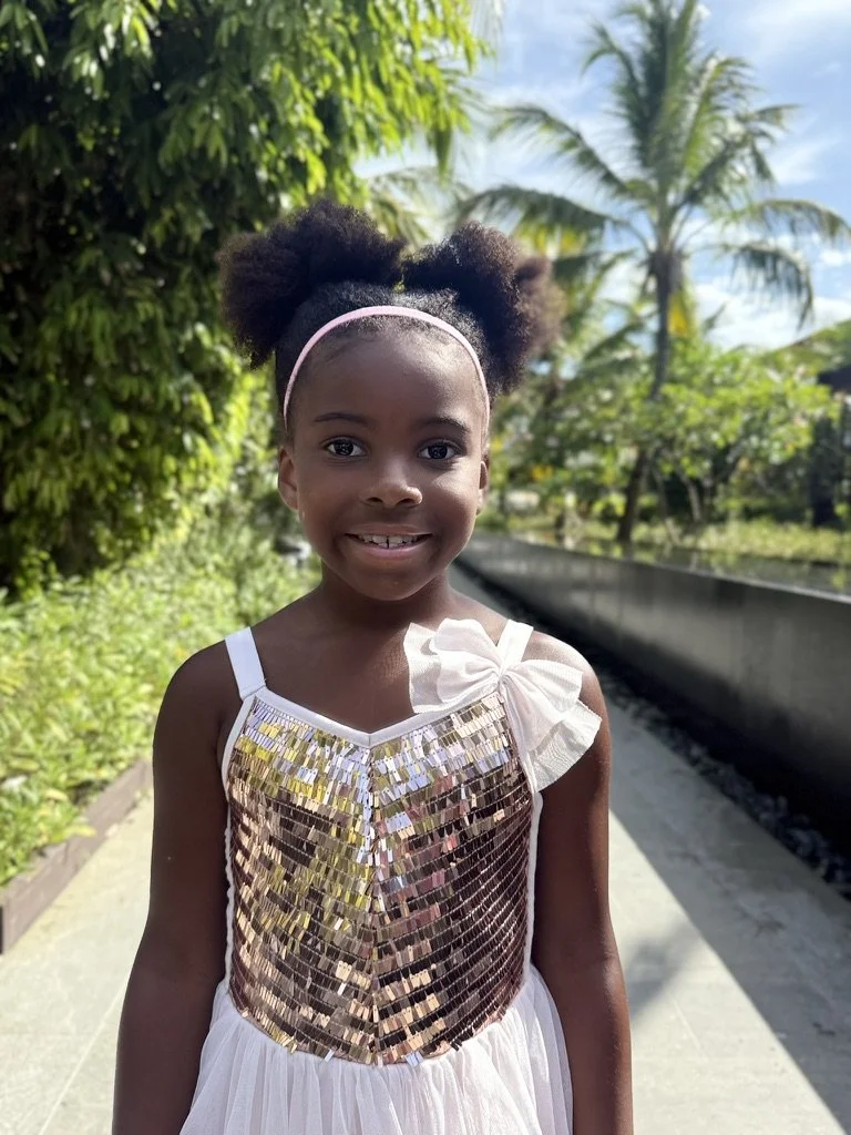 Piper Bryan, VP of Fun at Sandpiper Vacations, smiling in a sparkly dress at a tropical resort