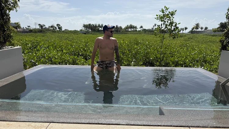 Sean Bryan in a private plunge pool overlooking tropical greenery