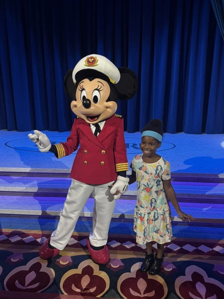 Piper Bryan holding hands with Captain Minnie Mouse onboard a Disney cruise