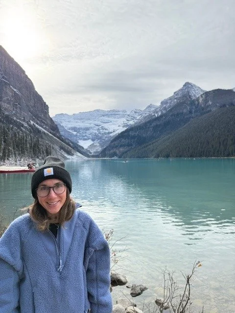 Alyssa LoVerso-Morgan at Lake Louise with snowy mountains behind her