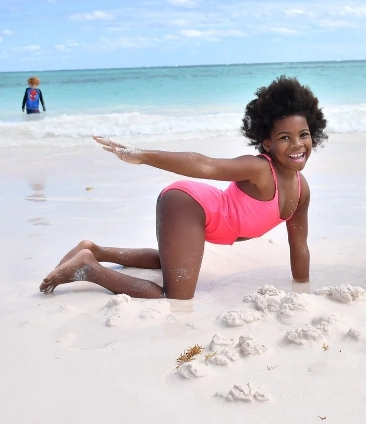 Piper Bryan smiling in the sand on a Bahamas beach