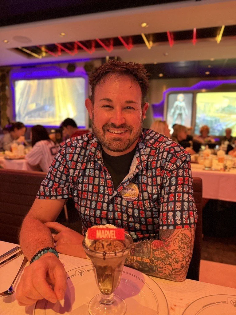 Sean Bryan, Director of Team Experience and Culture at Sandpiper Vacations, smiling at a Marvel themed dinner on a Disney cruise