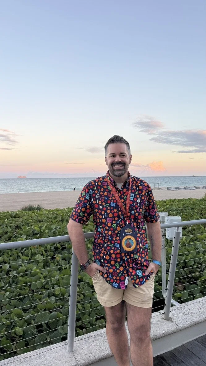 Nick Bryan standing by the beach at sunset with a Disney Destiny lanyard