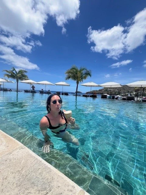 Alyssa LoVerso-Morgan enjoying a drink in a resort infinity pool