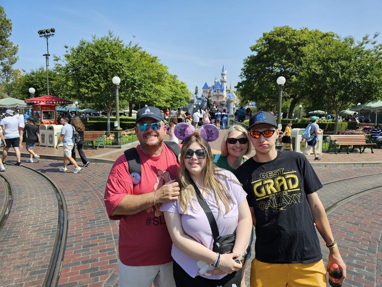 Kara Hull and her family on Main Street at Disneyland with Sleeping Beauty Castle behind them