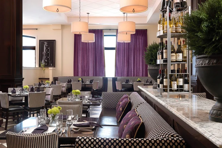 Bix Bistro dining room with booth seating, pendant lights and a wine display