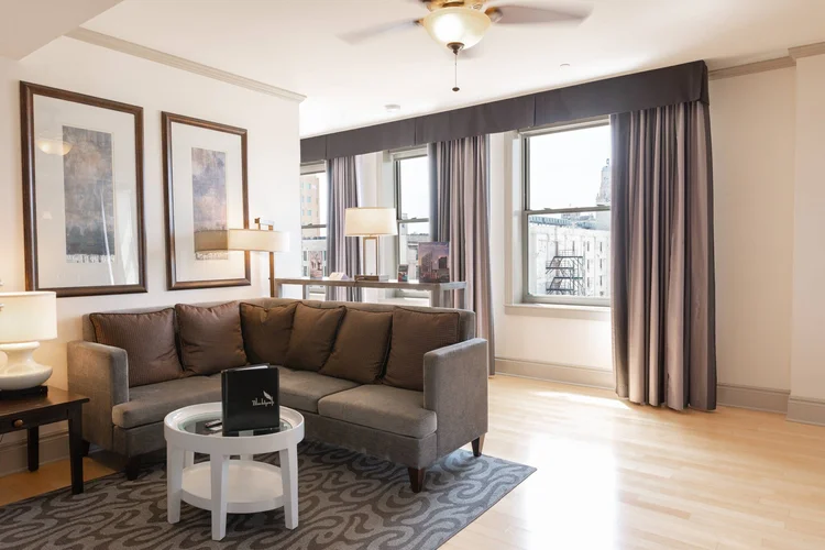 Suite living room with a sectional sofa and tall windows