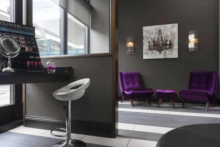 The Spa seating area with purple chairs and a makeup station
