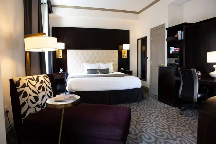 King Premier guest room with a tufted headboard and a plum chaise