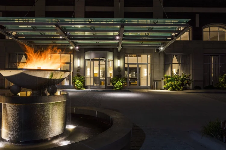 Hotel Blackhawk's front entrance at night with the fire fountain and glass canopy