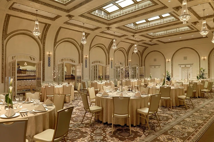 The Gold Room set for a reception with round tables, chandeliers and a skylight