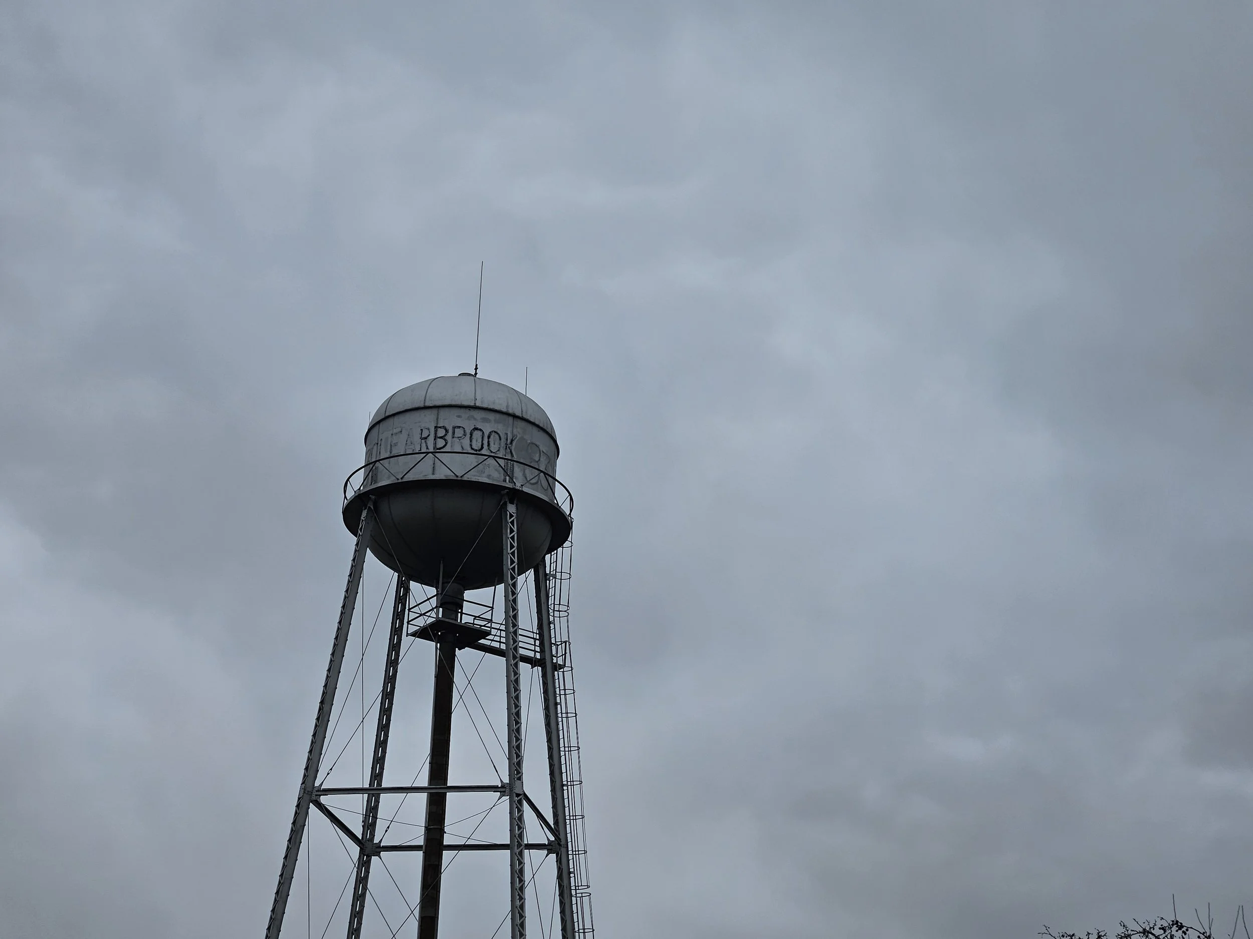Small-town water tower against an open sky, representing the municipal water systems hit in the 2026 Iran-linked cyberattack on American critical infrastructure.