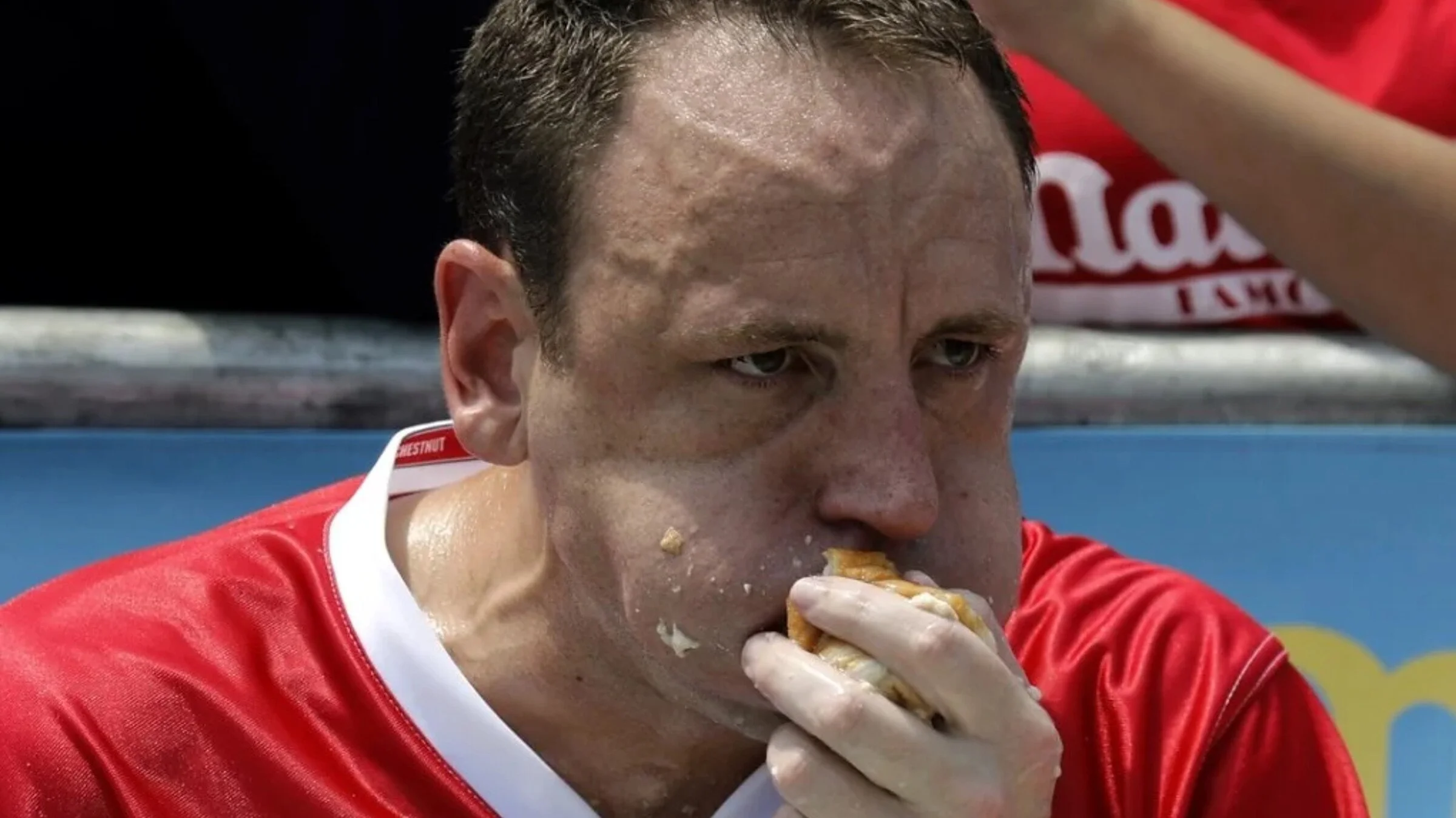 A competitor mid-bite at a hot dog eating contest.