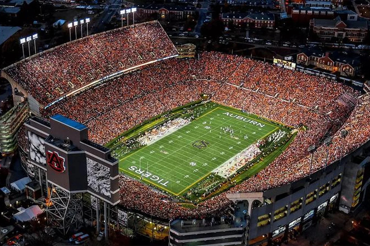 Jordan-Hare Stadium in Auburn, Alabama, seen from the air at night, the field lit and the stands full.