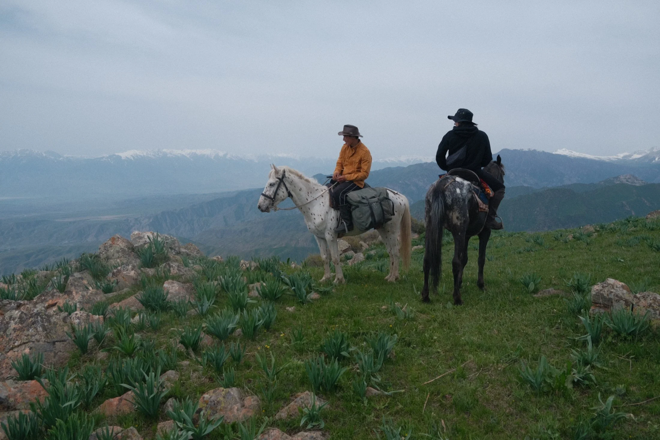 Yrys on a white spotted horse on a ridge above the reservoir