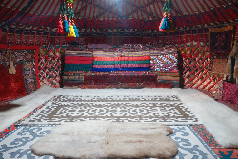 Inside a traditional Kyrgyz yurt, with felt carpets and embroidered hangings