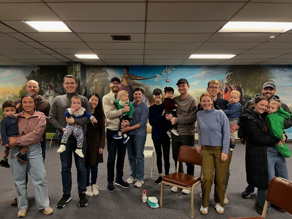 Families with Littles: parents holding babies and toddlers in the St. John's mural room