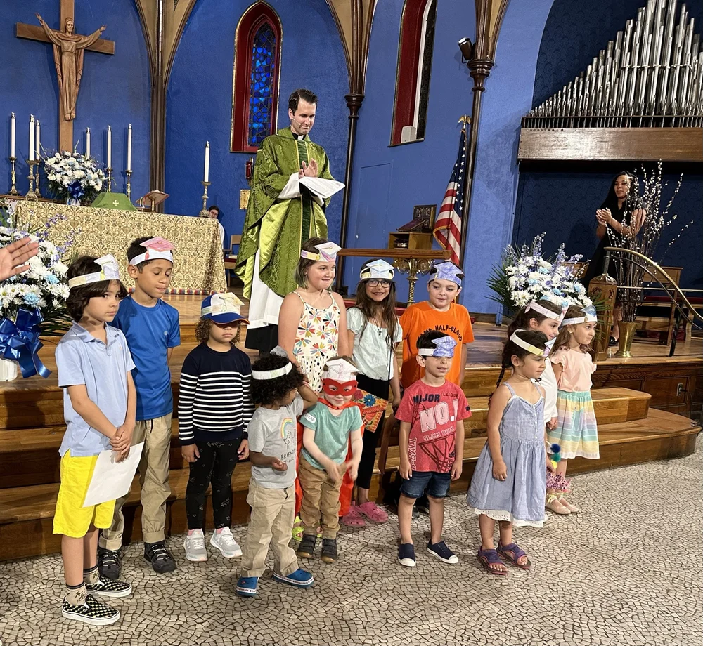 Sunday School children in paper crowns with Rev. Ben DeHart in the St. John's chancel