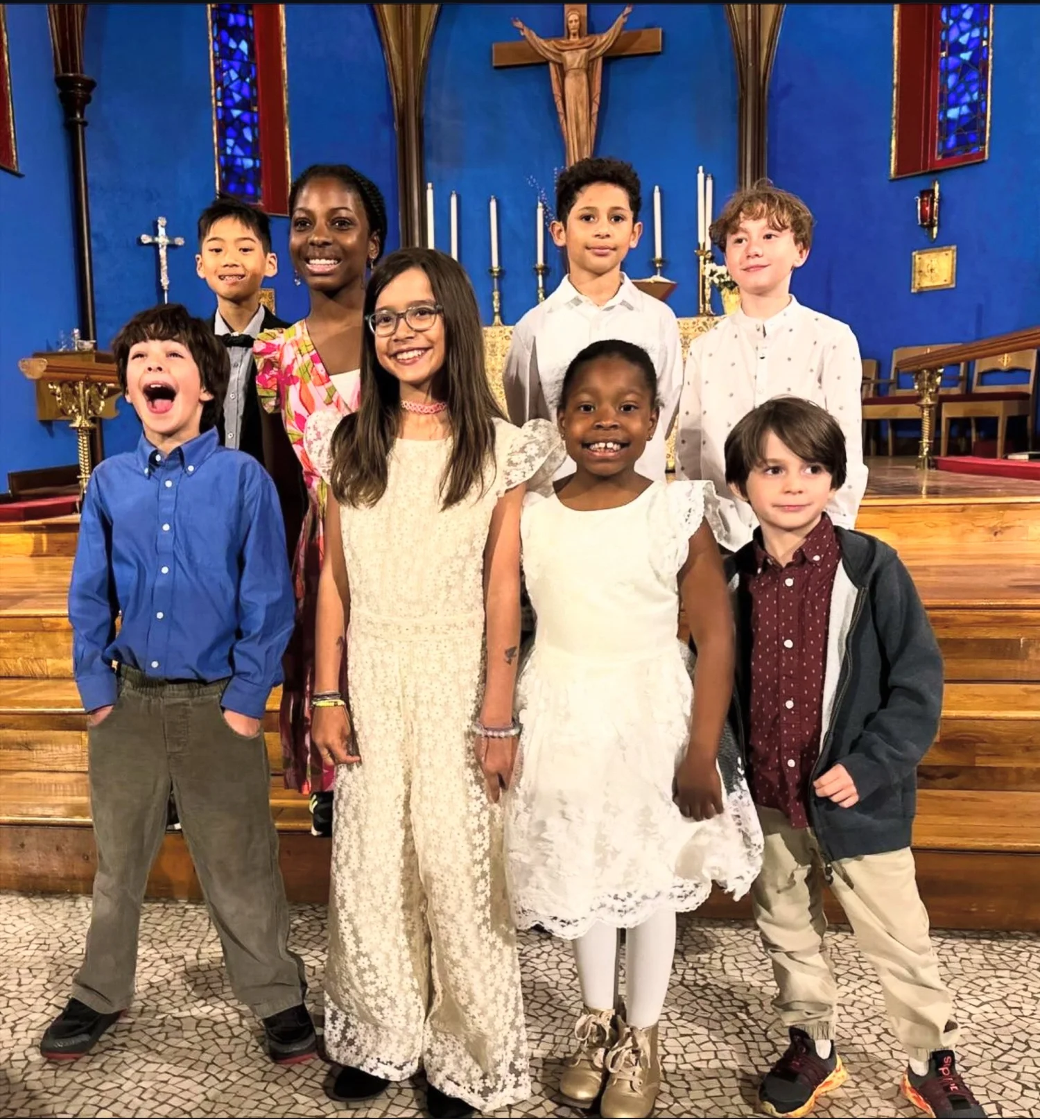 Smiling St. John's children dressed up in front of the altar