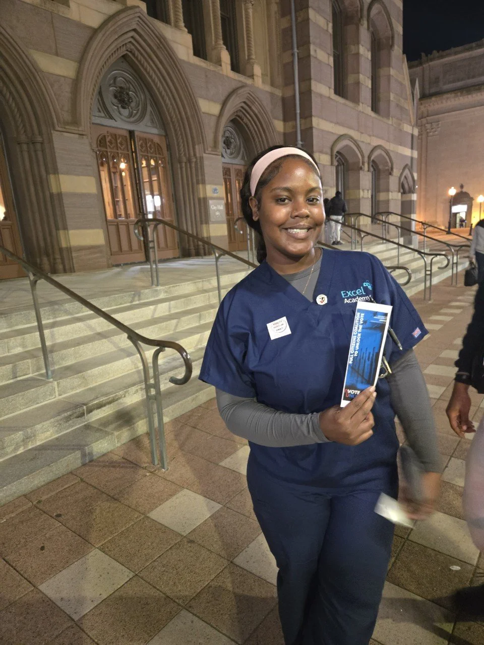 A woman holds an Unlock the Vote guide outside New Haven City Hall