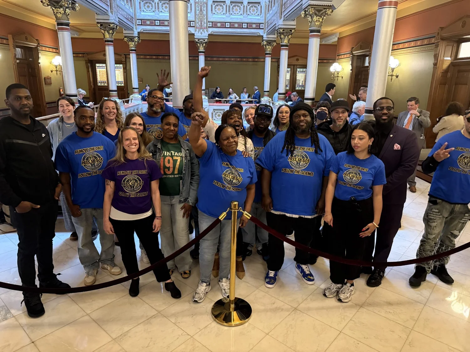 FCC members in blue shirts inside the Connecticut State Capitol