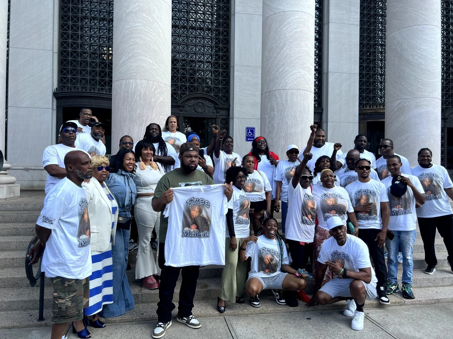 Supporters in matching photo t-shirts gather on courthouse steps