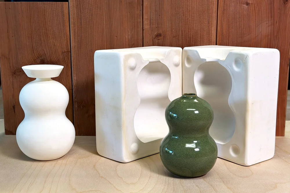 A white 3D-printed vase model, the two-part plaster mold made from it, and the finished green glazed vase