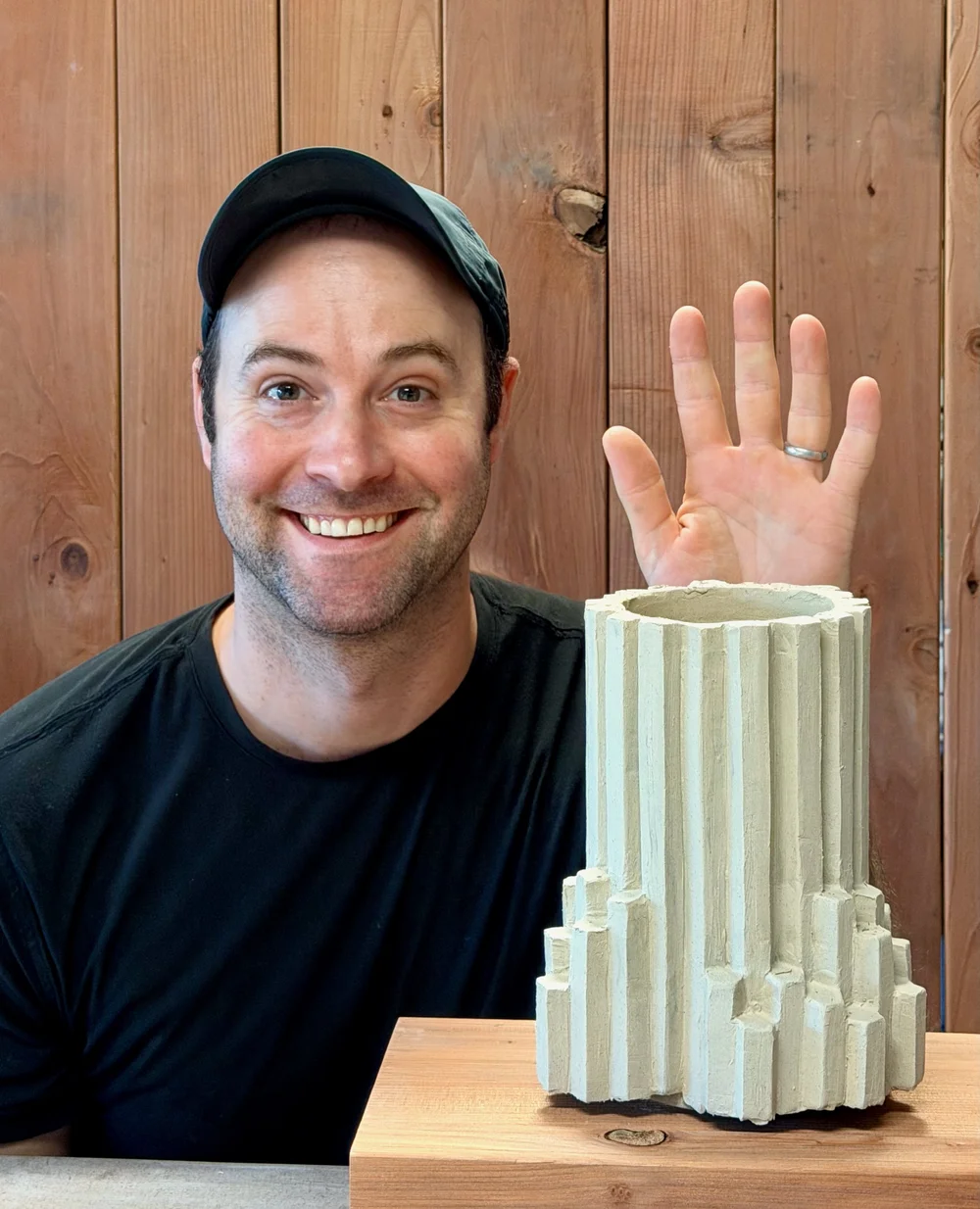 Josh smiling and waving in his studio