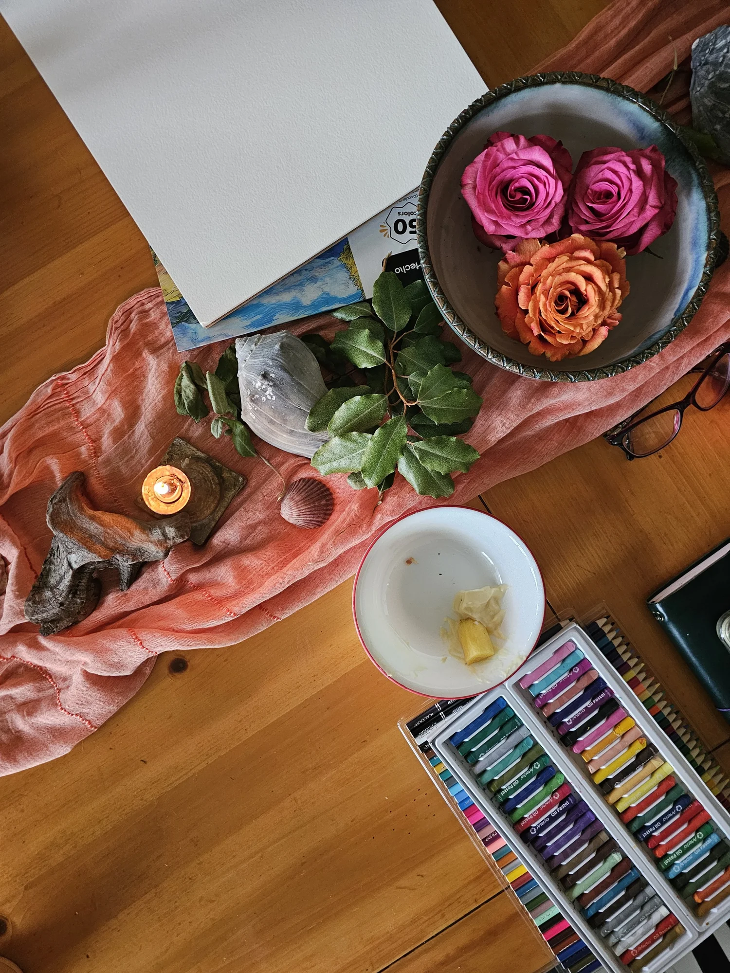 Pastels, roses and a candle on the ritual cloth