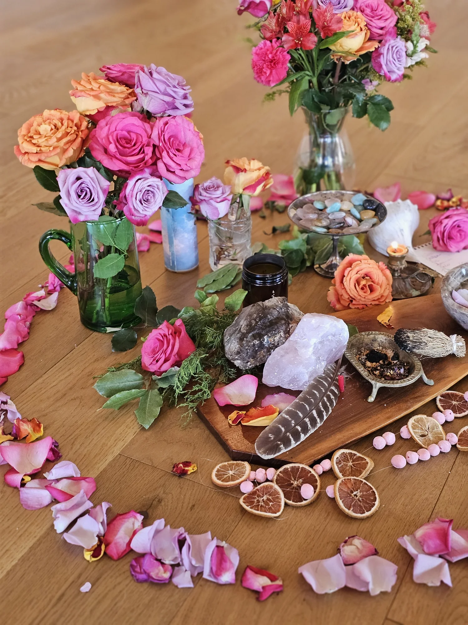 Roses, dried citrus, feathers and stones laid on the altar board
