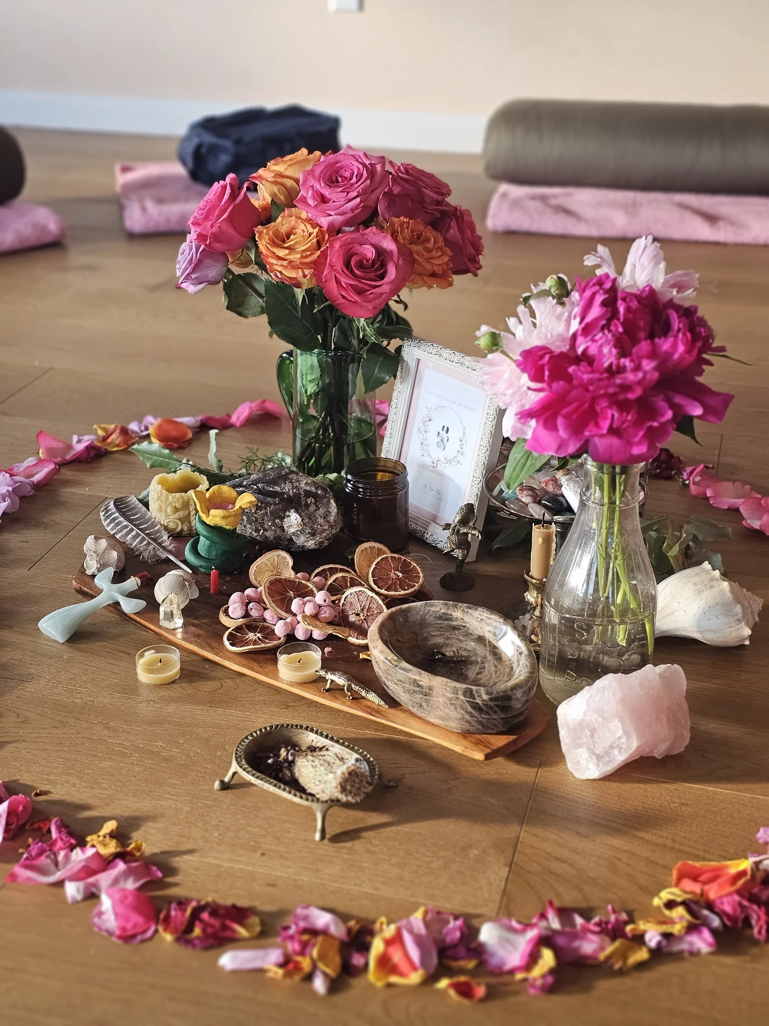The center altar — roses, crystals, candles, a ring of petals
