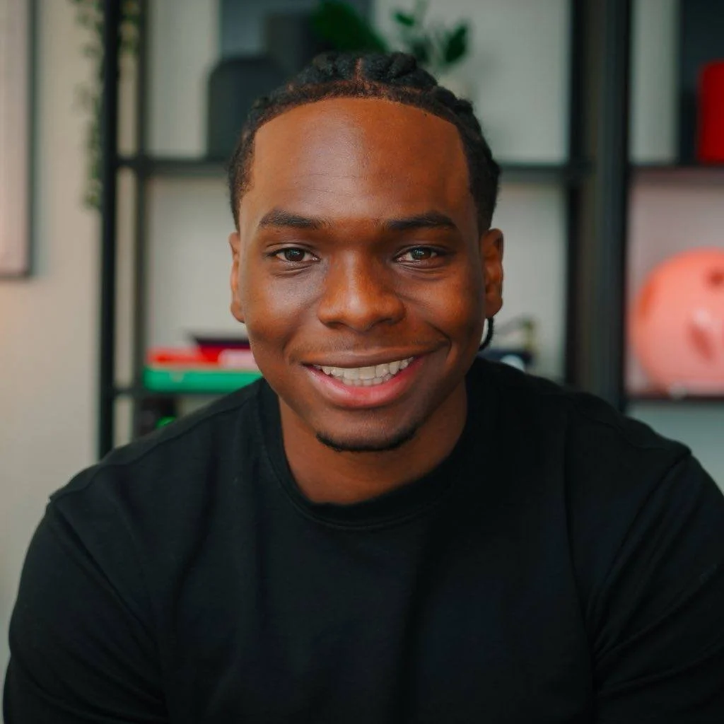 Shevon Salmon smiling, in a black t-shirt, in front of shelves.