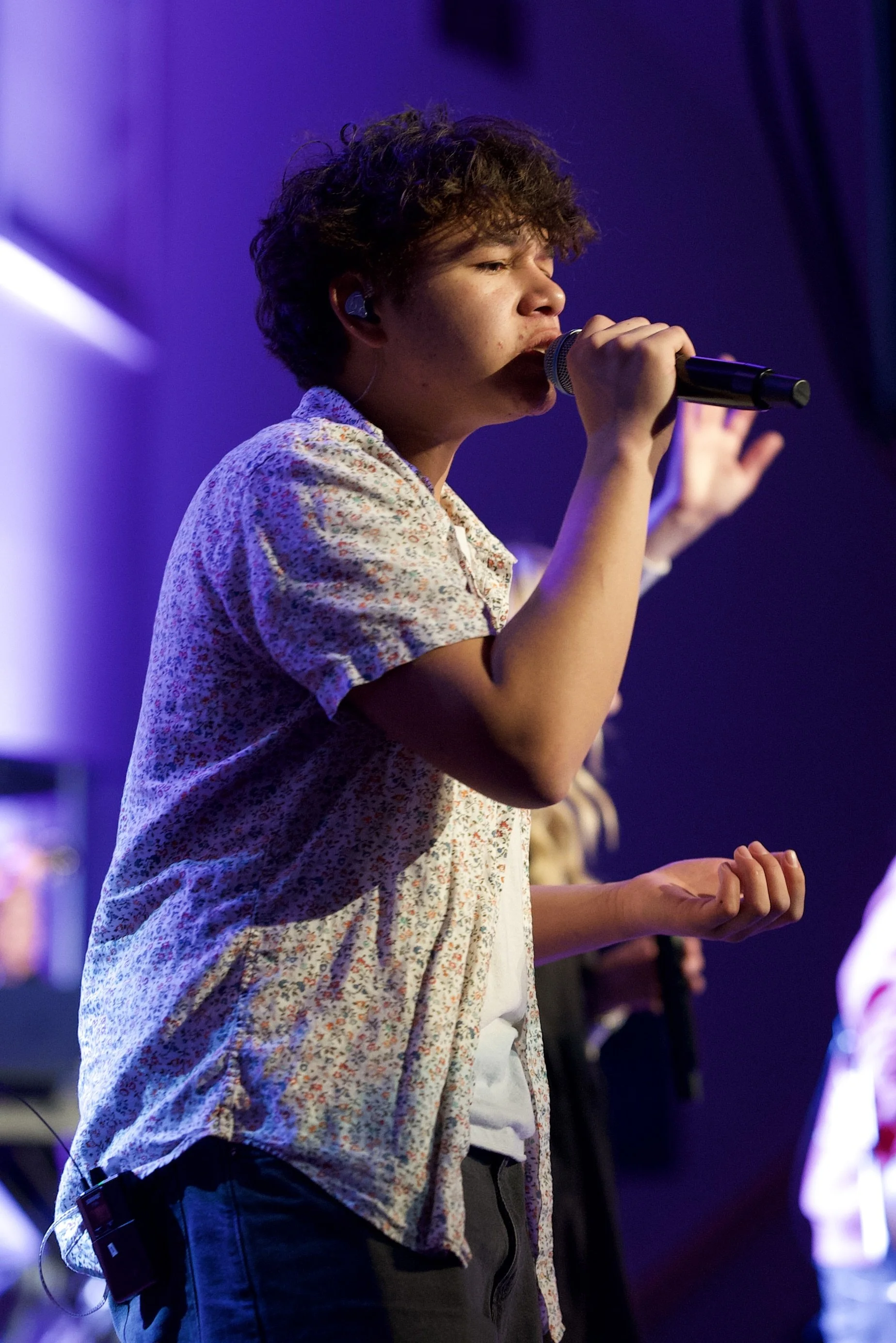 A worship team member singing on a Sunday at Journey Church