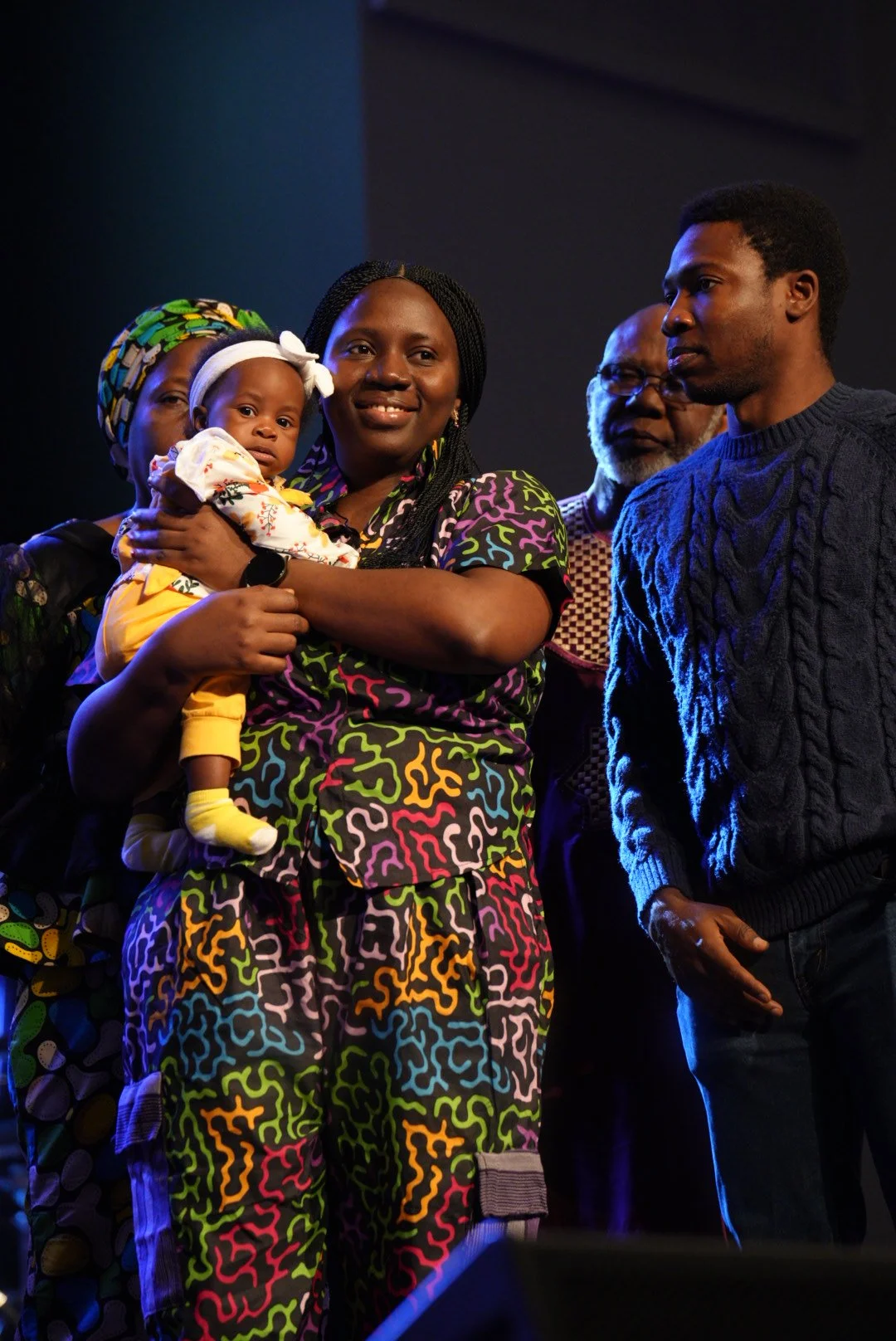 A mother holding her baby during a child dedication at Journey Church