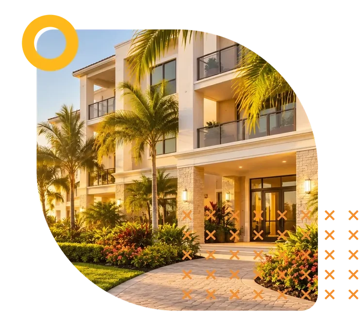A waterfront Florida condominium building with balconies and palm-lined landscaping at sunset
