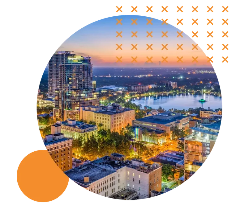 Downtown Orlando at dusk, with Lake Eola and its fountain beyond the city lights