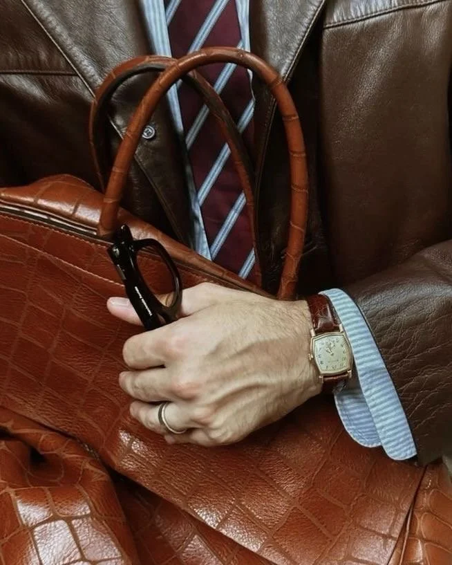 Menswear details: brown leather, a tie, and a vintage watch