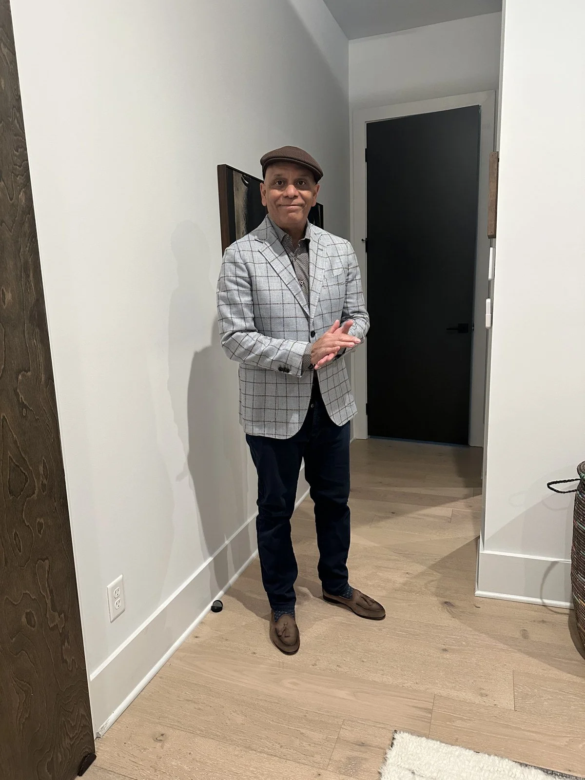 Gray checked blazer styled with dark trousers and a hat