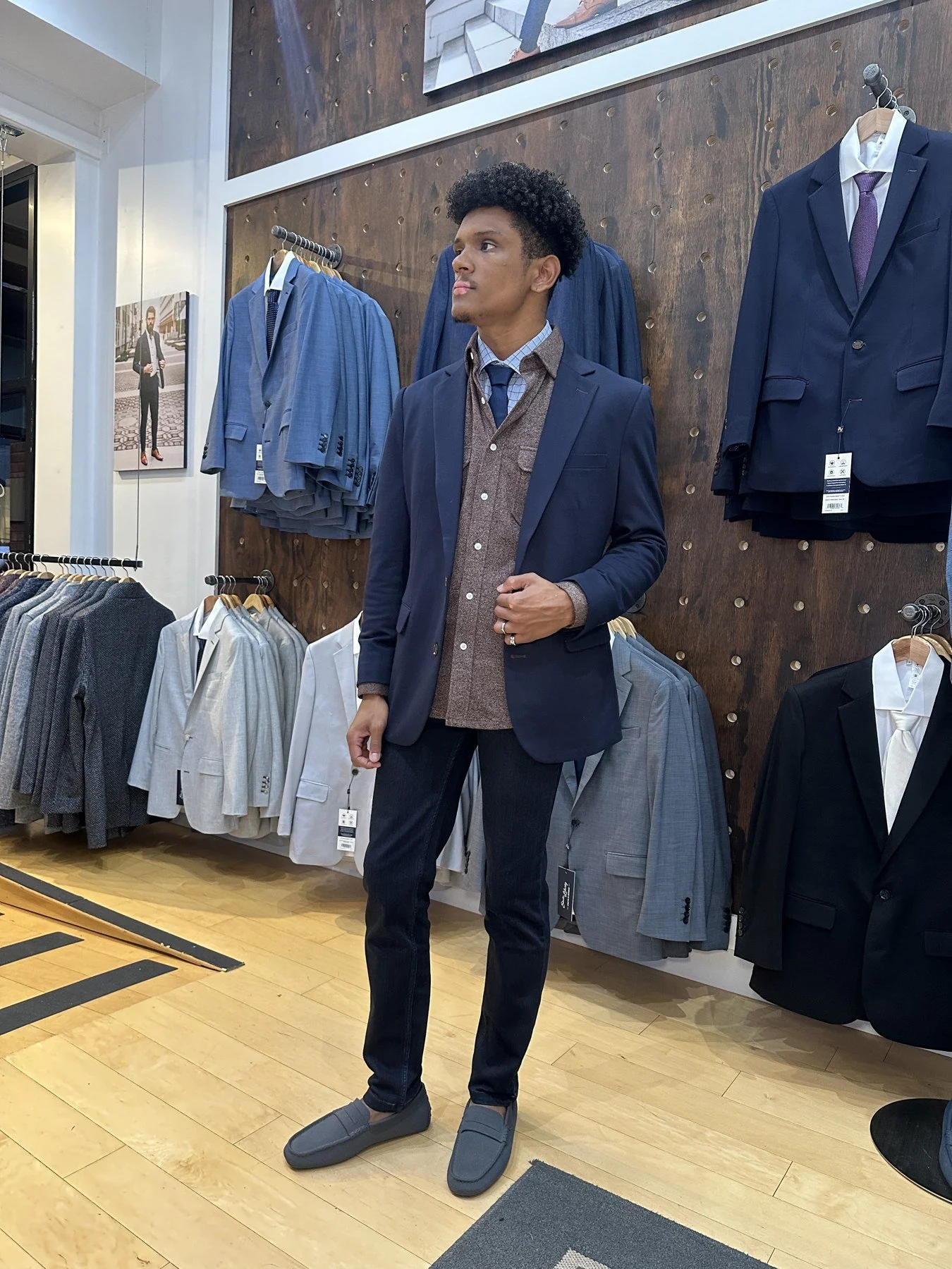 Client wearing a navy blazer and brown layers during an in-store styling session.